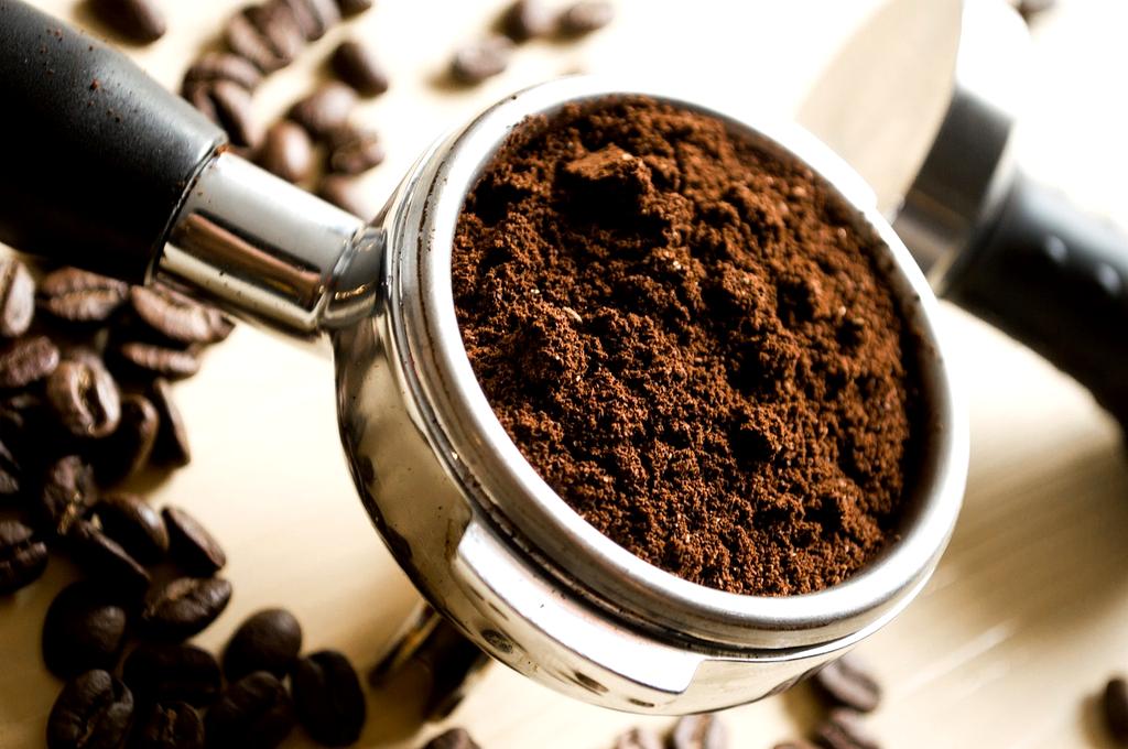 Bicchiere di Aperol Spritz con ghiaccio, fetta d'arancia e olive verdi su tavolino di legno