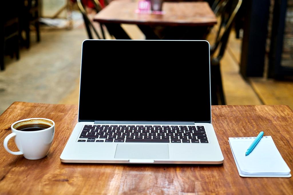 Immagine di Giulia Ferrari, giovane donna sorridente seduta al tavolo della caffetteria