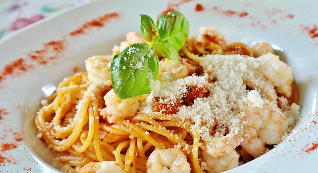 Primo piano di un piatto di pasta fresca con pomodorini e basilico
